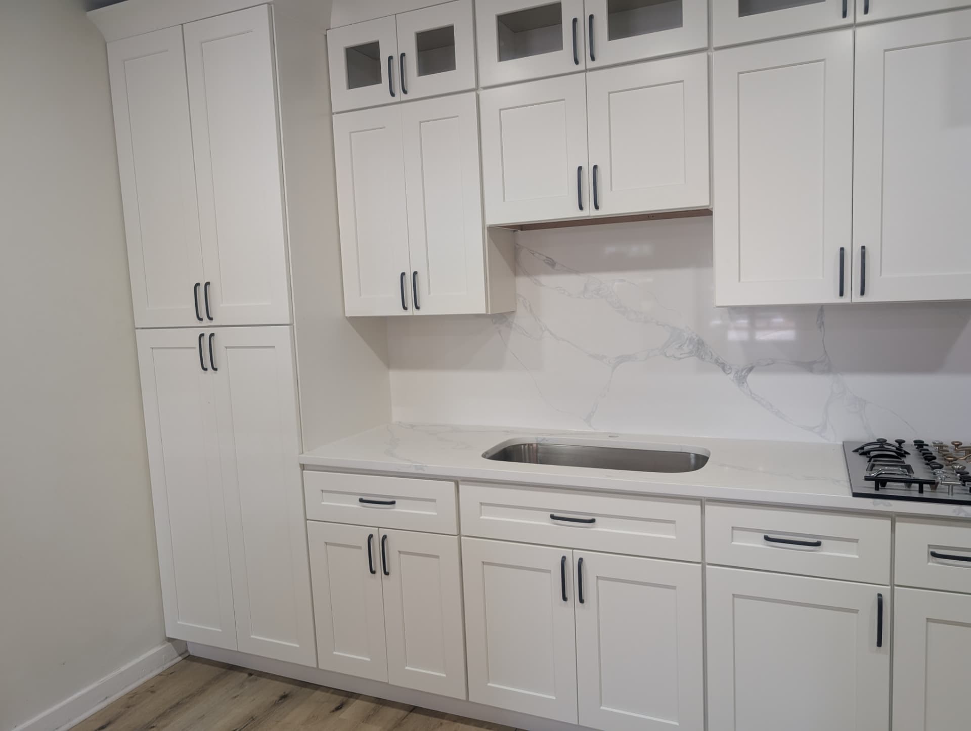 White shaker cabinets paired with a Calacatta-style quartz countertop and full-height backsplash in a Lawrenceville, GA showroom display
