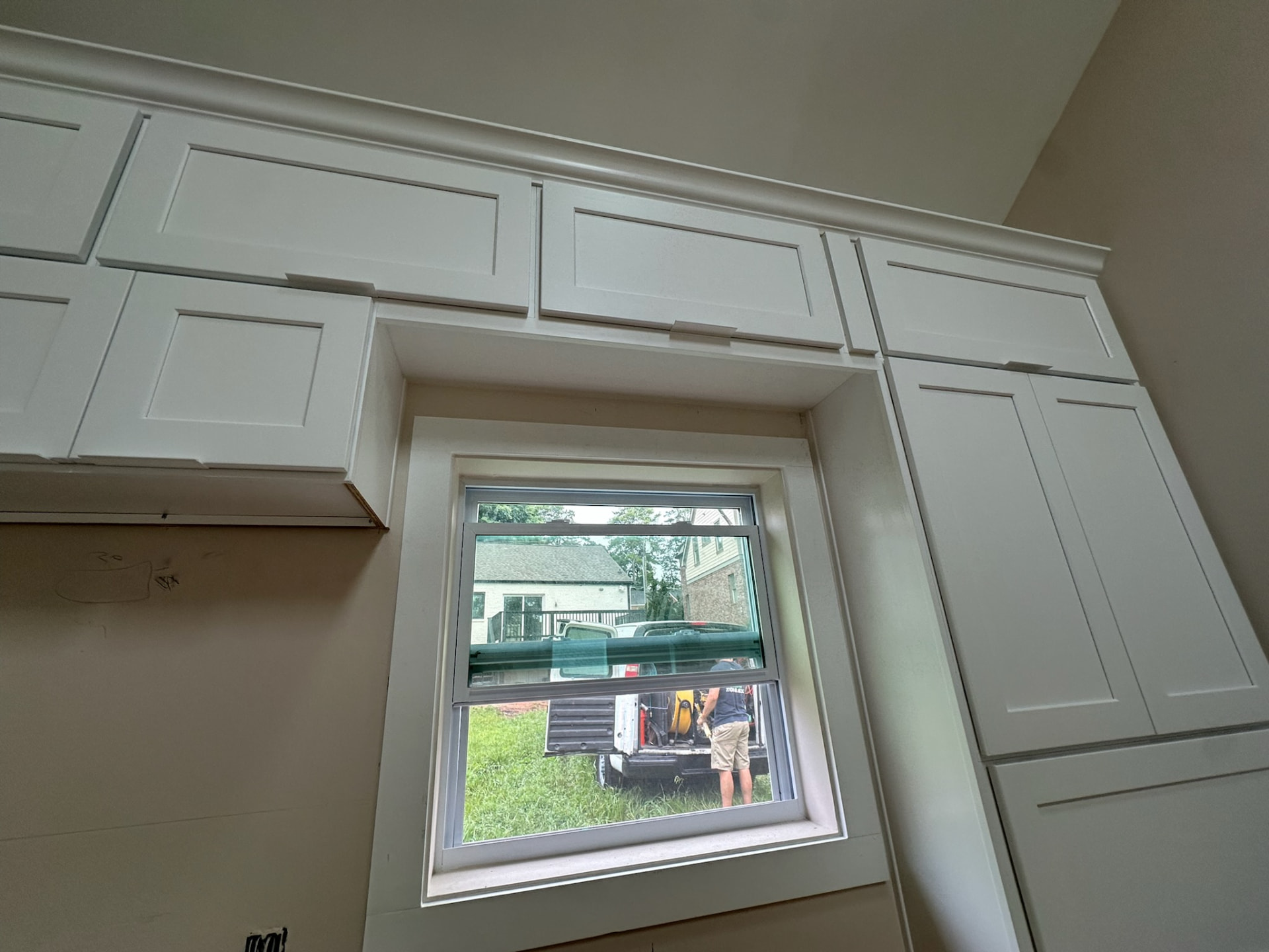 White painted kitchen cabinets and crown molding framing a window in a Suwanee kitchen remodel